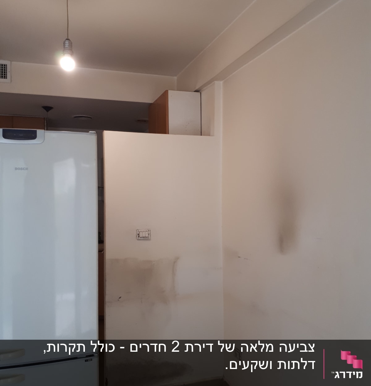 קיר עם כתמי צבע כהים וכתמי לכלוך